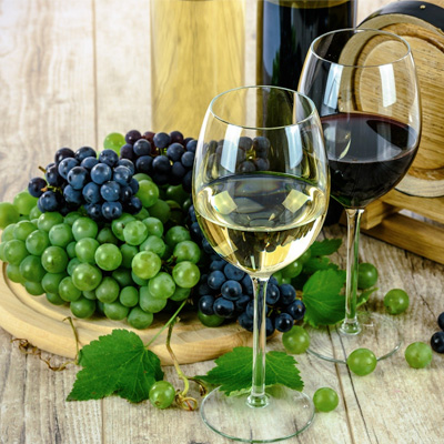 Foto zeigt zwei Weingläser gefüllt mit Weißwein und Rotwein